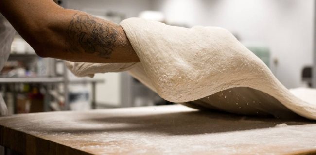 Pizza chef throwing dough.